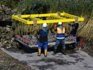 Die Ufermatratzen werden mithilfe einer speziellen Vorrichtung in Position gebracht und anschließend auf dem Geotextil befestigt