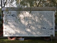 Ein anderes Plakat, auf dem ein handgeschriebener Text abgebildet ist, ist auf einem Wagon befestigt. Der Wagon wird an verschiedenen Standorten aufgestellt.