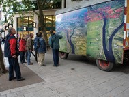 Ein Plakat, welches Wilhelmsburg zwischen den zwei Elbarmen aus der Vogelperspektive abbildet, ist auf einem Wagon befestigt. Der Wagon wird an verschiedenen Standorten aufgestellt.